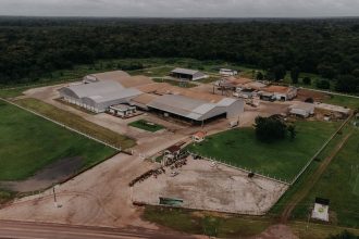 Vista aérea de uma planta industrial com galpões e áreas verdes ao redor