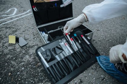 Close de instrumentos de investigação forense dispostos em uma cena de perícia.