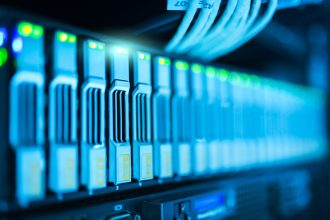 Rack de servidores com luzes azuis em um moderno centro de processamento de dados.