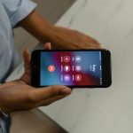 Pessoa segura um smartphone com a tela exibindo uma chamada recebida.