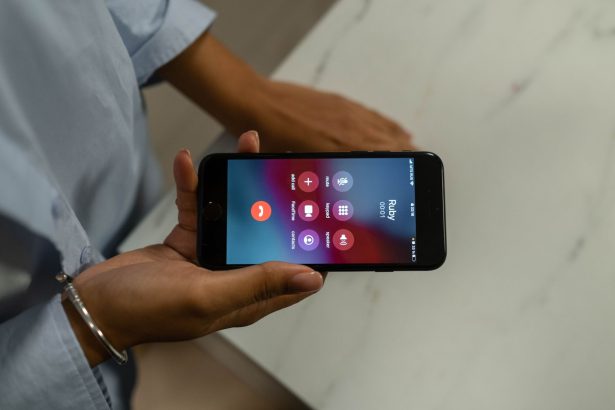 Pessoa segura um smartphone com a tela exibindo uma chamada recebida.